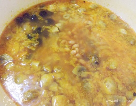 Выложить фасоль и маслины в суп, довести до кипения и томить на очень медленном огне около 10 минут.