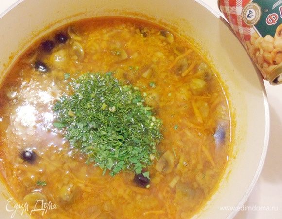 Выключить огонь, добавить мелко нарезанную свежую зелень, перемешать, накрыть кастрюлю крышкой и дать настояться хотя бы полчаса.