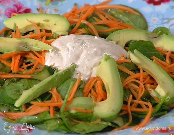 На большое блюдо выложить шпинат, огурец, морковь, авокадо, а в центр заправку.