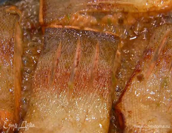 Разогреть в сковороде оливковое масло, выложить рыбу кожей вниз и слегка обжарить, затем полить маринадом, обжарить с двух сторон до готовности и посыпать кунжутом.