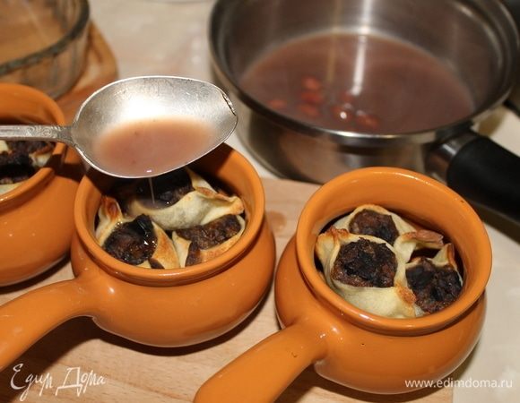 Переложите кундюмы в горшочки, добавьте горячий фасолевый соус и грибной отвар.