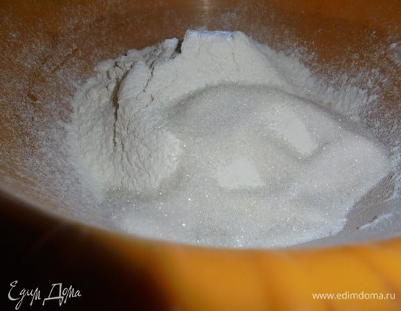 Просеять в миску муку с разрыхлителем. Добавить сахар.