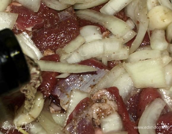 На дно жаропрочной посуды, в которой будем готовить мясо, кладем несколько веточек розмарина. Выкладываем мясо и добавляем 200 мл десертного вина.