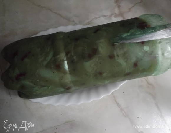 Застывший рулет достаньте и разрежьте бутылку вдоль.