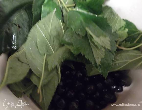 Листья вишни и смородины тоже промыть и добавить к ягодам.
