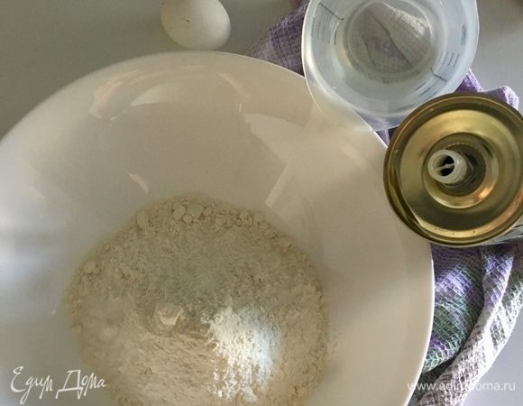 Сначала приготовим вытяжное тесто. Просеять в миску муку с щепоткой соли. Вбить одно яйцо, влить 3 столовые ложки оливкового масла и понемногу начать добавлять теплую воду.