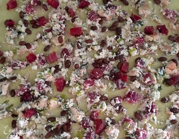 На пласт теста равномерно выкладываем всю начинку и с помощью полотенца скручиваем в тугой рулет. Края защипнуть.