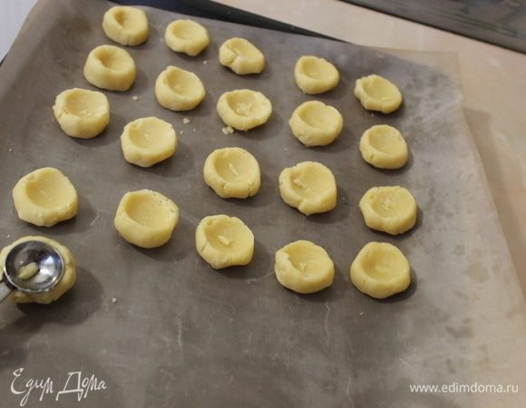 Из теста скатайте шарики размером с грецкий орех и посередине сделайте углубление. Можно пальцем. Я взяла подручный иструмент.