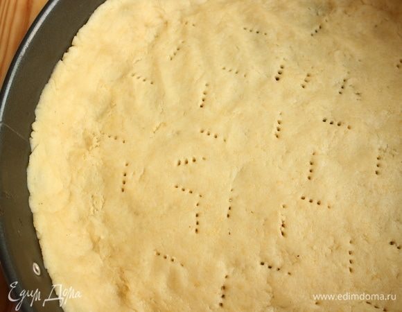 Большую часть теста немного раскатать, положить на слегка смазанное сливочным маслом дно формы, расправить по дну равномерно, наколоть вилкой дырочки, одеть борта формы, смазать их также слегка сливочным маслом, сделать из теста бортики. Убрать форму с тестом в холодильник, пока вы будете раскатывать тесто для верха пирога.