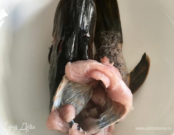Берем готовую к фаршировке щуку. Отодвигаем ей голову в сторону. Максимально раскрываем полую кожу, как на фото.