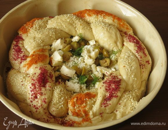 По кругу выкладываем косу из теста, посыпаем кунжутом, сумахом, шафраном.