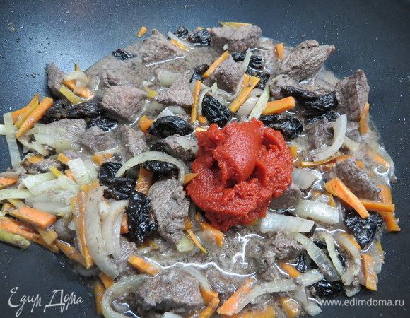 Спустя 15 минут добавить в сковороду крупно нарезанный чернослив и томатную пасту, перемешать, тушить еще 15–20 минут.