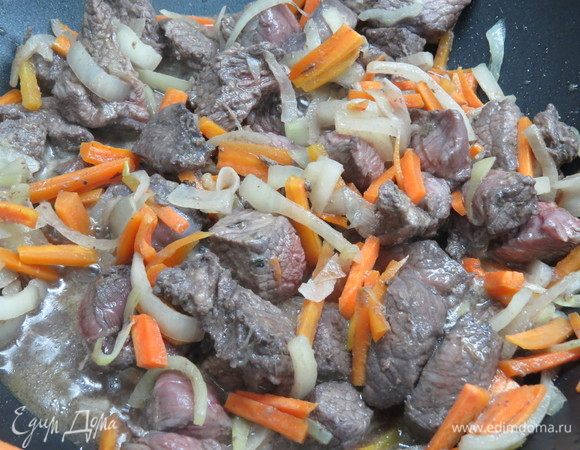 Добавить в сковороду к луку и моркови замаринованное мясо (маринад предварительно слить, но не выливать), обжарить до румянца.