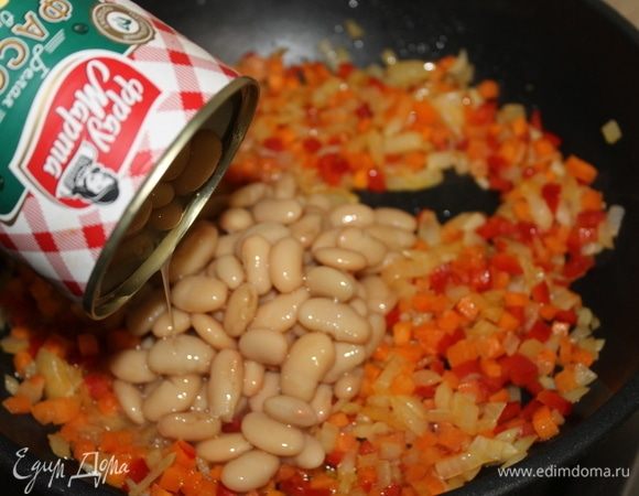 На оливковом масле обжарьте нарезанные овощи. Как лук станет прозрачным, добавьте к овощам фасоль, предварительно слив заливку.