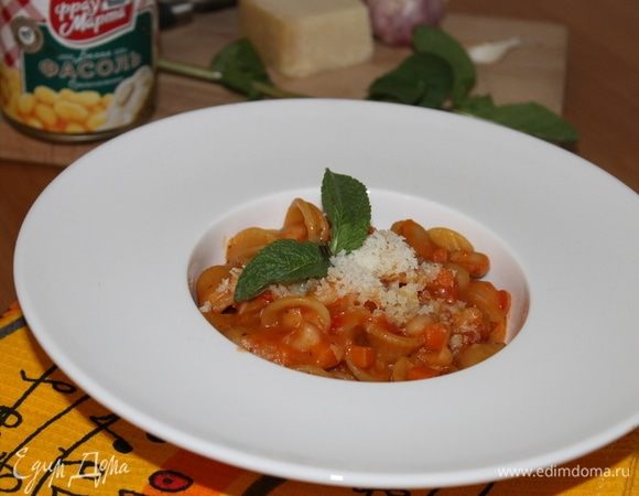 В готовую пасту добавьте зелень, обильно сверху натрите сыр.