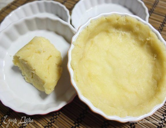 Тесто делим на четыре части. В формы для выпечки выкладываем каждую часть и пальцами распределяем по форме, формируя основу.