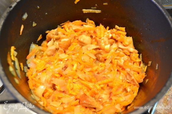 Затем добавляем натертую морковь и размороженные белые грибы, обжариваем до готовности. Выложить в тарелку, добавить чеснок, зелень.