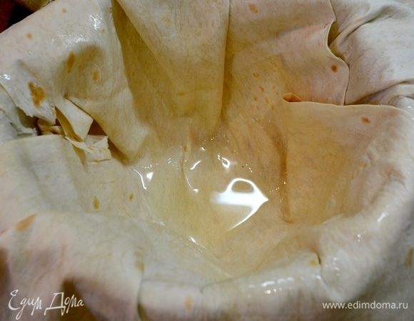 В казан укладываем наши лаваши, смазываем слои маслом, оставляем края, чтобы накрыть затем плов сверху.