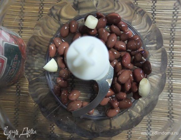 В чашу блендера выкладываем фасоль и чеснок. Измельчаем.