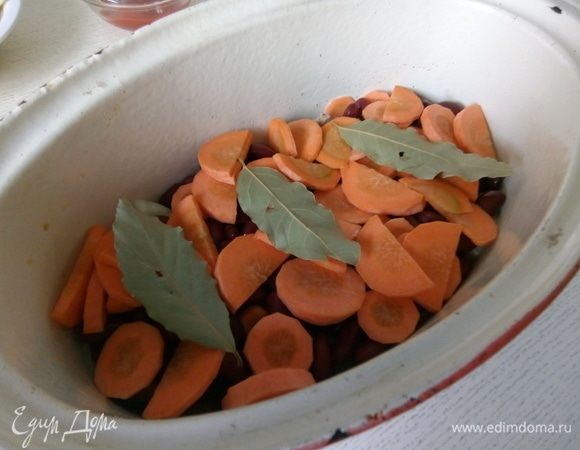 Морковь чистим, моем, нарезаем на кружочки, если морковь толстая, на четвертинки круга. Выкладываем на фасоль. Сверху кладем лавровый лист.