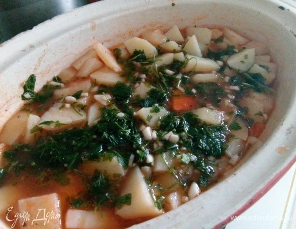 Пока все это запекается, готовим смесь из зелени и чеснока. Мелко рубим очищенный и помытый чеснок, добавляем к нему зелень. Кто любит поострее, можно добавить жгучий перец. Добавляем зелень с чесноком в почти готовое блюдо и ставим в духовку еще минут на 10. Подавать к столу, конечно, лучше горячим, добавить сметаны. И приятного аппетита!