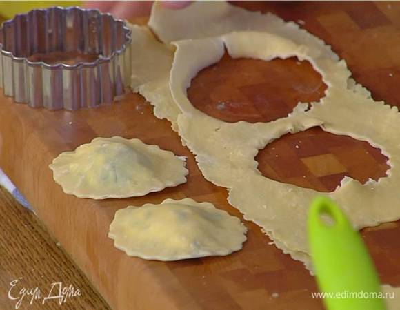 На одну половину теста поместить начинку, выкладывая по чайной ложке на некотором расстоянии друг от друга, смазать тесто вокруг начинки белком, накрыть второй половиной теста, прижать тесто вокруг начинки и круглой формочкой вырезать равиоли или нарезать на квадраты ножом.