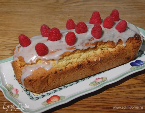 Готовый теплый кекс покрыть сахарной глазурью и украсить свежей малиной.
