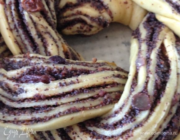 Разрезать рулет вдоль на две части, отступив от начала сантиметров 5, вывернуть начинкой вверх и сплести косу. Соединить рулет в виде кольца и оставить в теплом месте минут на 10. Выпекать в разогретой до 180°C духовке около 25 мин.