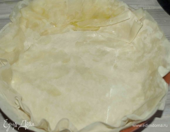 Каждый лист смазываем оливковым маслом. И выкладываем в форму, образуя бортики.