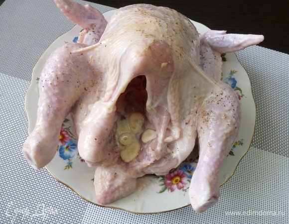 Чеснок нарезать и положить внутрь тушки.