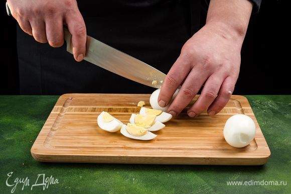 Очистите яйца и разрежьте на дольки.