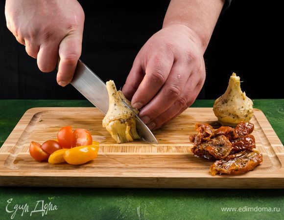 Промокните бумажной салфеткой лишнее масло на вяленых томатах и артишоках. Томаты нарежьте полосками, артишоки — четвертинками. Промойте помидоры черри и нарежьте пополам. Смешайте все ингредиенты.<br />
 