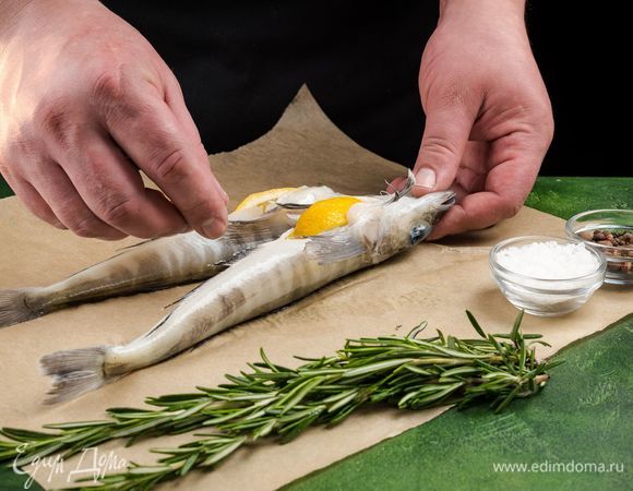 Натрите рыбу крупной морской солью и смесью перцев. Лимон нарежьте дольками, положите в рыбу.<br />
 