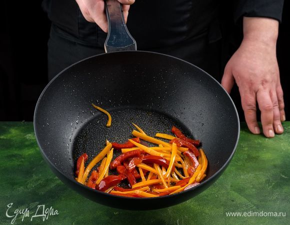 Смажьте сковороду оливковым маслом и обжарьте перец и морковь на сильном огне в течение минуты.<br />
 