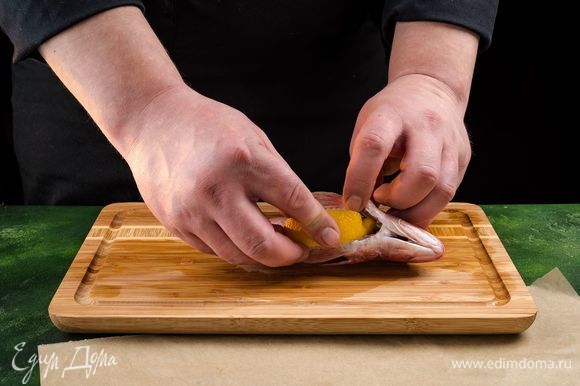 Натрите рыбу солью и перцем, положите дольку лимона внутрь.