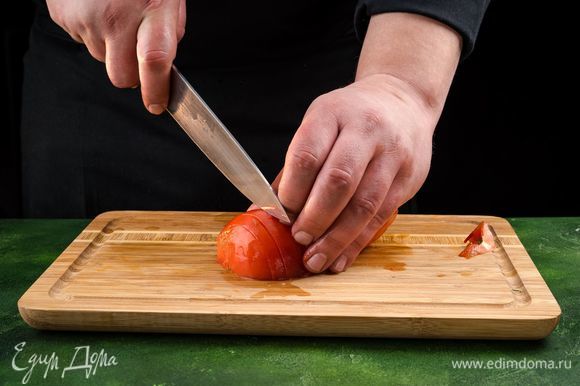На помидоре сделайте крестообразный надрез, опустите его в кипящую воду на 30 сек., затем обдайте холодной водой и очистите от кожицы. Мякоть мелко нарежьте.