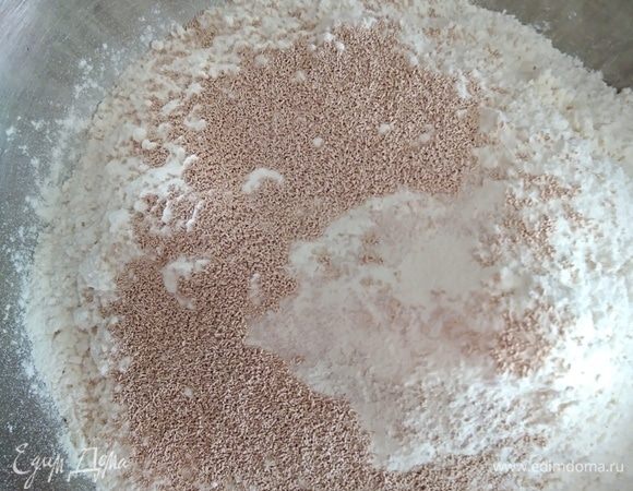 Начнем приготовление с домашнего теста для пиццы. Просеять муку и дрожжи в миску. Добавить соль, перемешать.