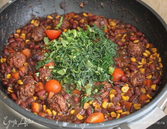 К концу приготовления добавьте зелень, половинки помидорок черри и доведите блюдо до готовности еще пару минут.