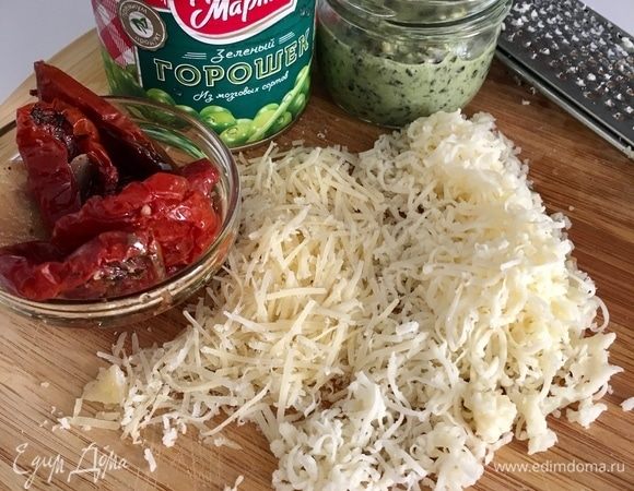 Сразу подготовим все остальные ингредиенты для начинки: вяленые в масле томаты (как всегда домашние), вкусный сладкий зеленый горошек ТМ «Фрау Марта» и два вида сыра — пармезан и плотная моцарелла, та, что для пиццы. Сыр натереть на мелкой терке.