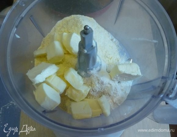 Для теста в комбайн сложить три вида муки, соль, перец. Добавить нарезанное кубиками масло и прокрутить недолго до состояния крошки.