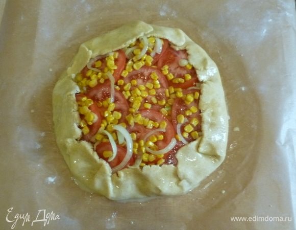 Посыпать оставшейся кукурузой и тимьяном. Завернуть края, смазать взбитым с 1 ст. л. воды яйцом. Убрать в холодильник на 15 минут.