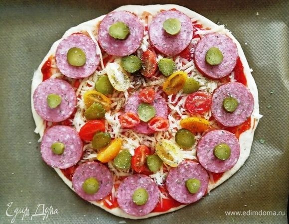 Выкладываем в один слой колбасу, черри, огурчики. Отправляем в духовку, разогретую на 200°С на 20 минут.