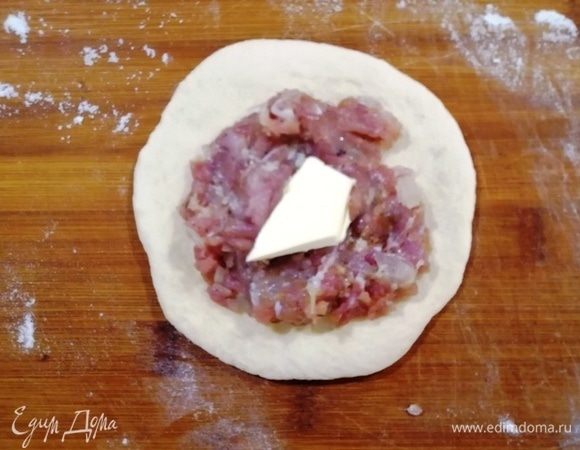 Лепим пирожки. Разминаем тесто в лепешку, выкладываем чайную ложку фарша и немного сливочного масла.