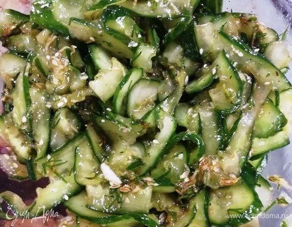 Огурцы хорошо отожмем от жидкости, смешаем с заправкой и польем кунжутным маслом. Перемешаем.