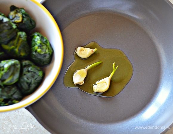 На оливковом масле обжарить раздавленные зубчики чеснока, после чего их удалить. На этом же масле потушить шпинат около 5 мин. (после разморозки получилось ровно 300 г), слегка посолив.