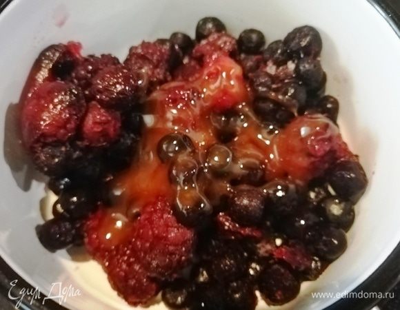 Приготовим сироп для пропитки манника, пока он остывает. Возьмем 1 стакан замороженных ягод и мед. Не размораживая ягоды, переложим их вместе с медом в сотейник.