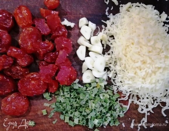 Сушеные помидоры черри и чеснок крупно нарезаем, сыр натрем, подготовим сушеный зеленый лук.