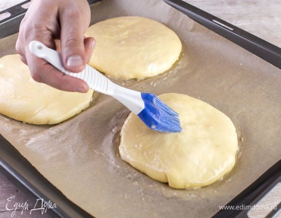 На выстланный пергаментом противень переложите получившиеся лепешки и смажьте их растопленным сливочным маслом.