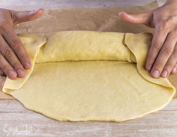 Сверните пирог в форме рулета и защипните край. Выпекайте в духовке при 180°C в течение 25–30 минут.