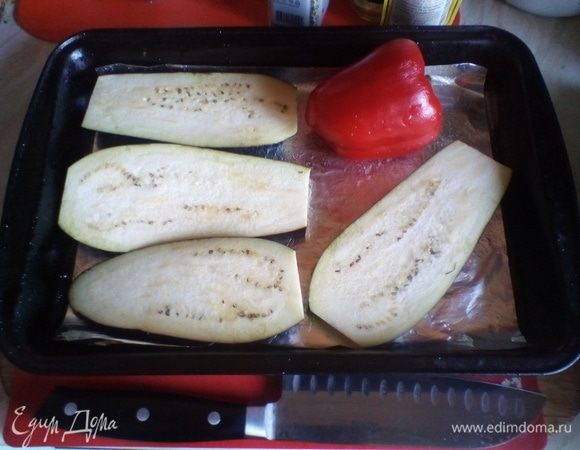 Разогреть духовку до 180–200°С. Баклажан нарезать полосками толщиной примерно 1 см, уложить на сбрызнутый растительным маслом противень. К нему добавить болгарский перец целиком. Отправить в духовку на 20 минут, забрать с противня баклажан, а перец будет печься еще 20 минут.